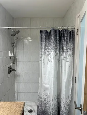a kitchen with white cabinets washer and dryer