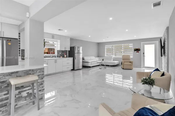 a living room with furniture and view of kitchen