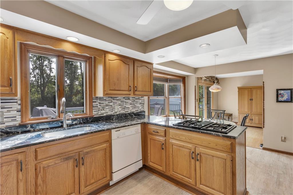 116 Rizzi Drive Irwin, PA 15642 - Photo 18 of 38 Jennair Cooktop with Grill, Stainless Steel Deep Farm Sink, and Gorgeous Tile Backsplash in the Kitchen.