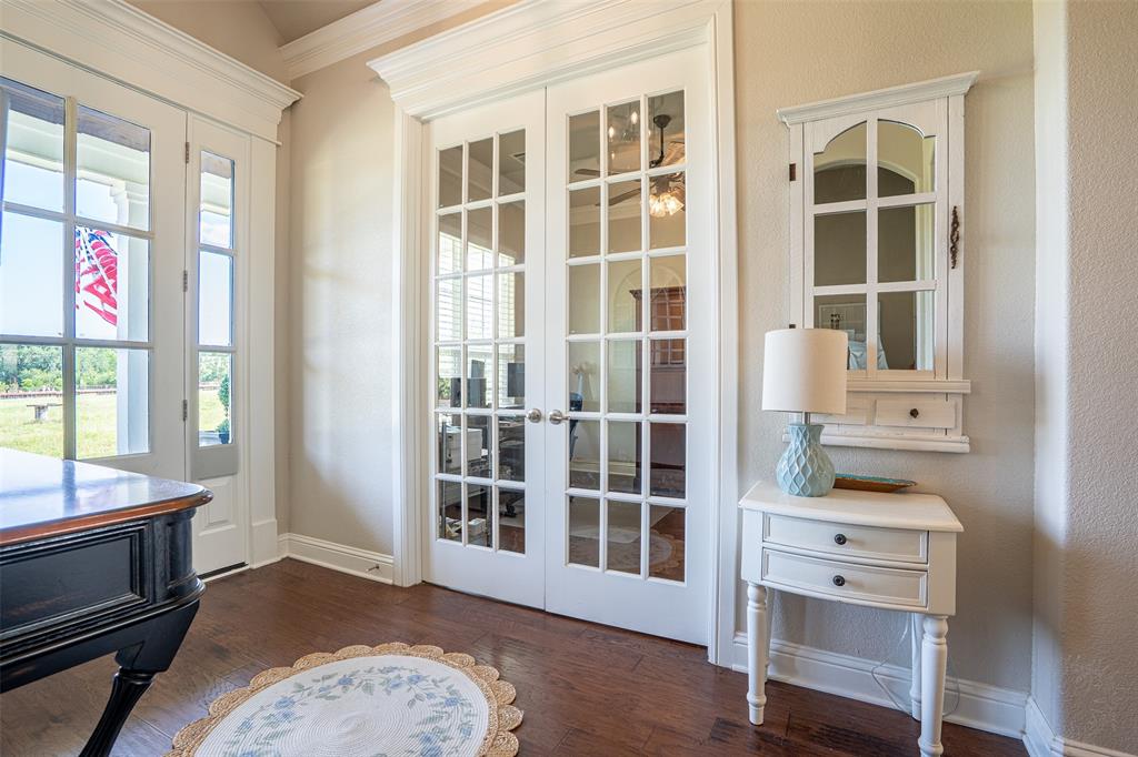 1920 Meander Road Granbury, TX 76049 - Photo 5 of 40 Double French doors with transom windows, rich wood-finish flooring, and crown molding