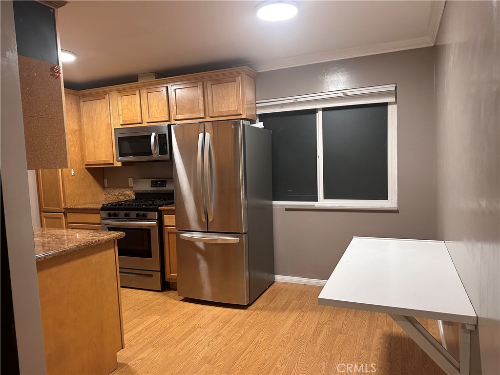 6600 Warner Avenue, Unit 210 Huntington Beach, CA 92647 - Photo 16 of 47 a kitchen with stainless steel appliances kitchen island granite countertop a refrigerator and a stove top oven