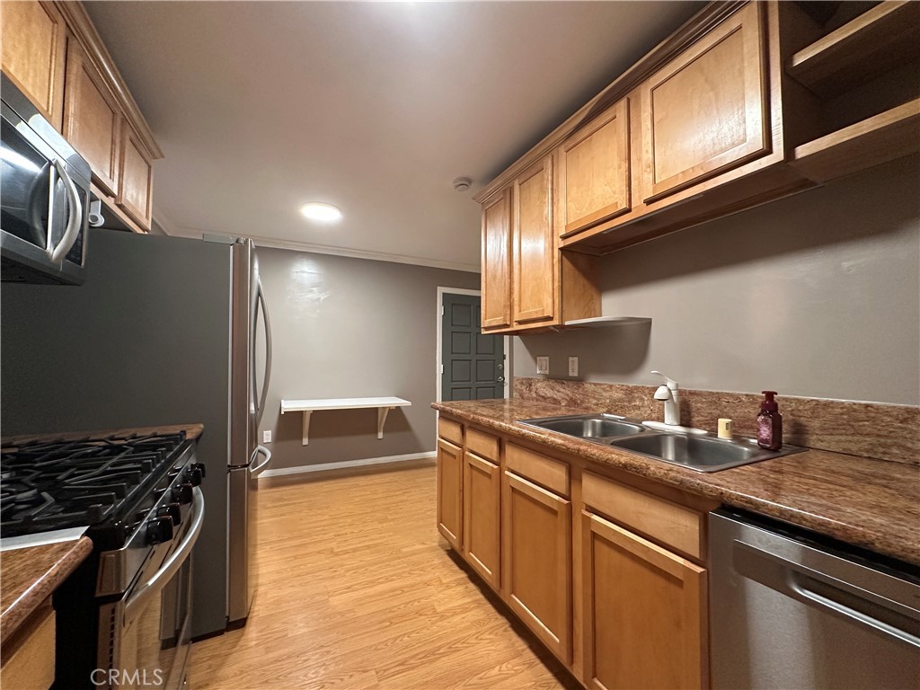 6600 Warner Avenue, Unit 210 Huntington Beach, CA 92647 - Photo 19 of 47 a kitchen with stainless steel appliances granite countertop a sink and a stove