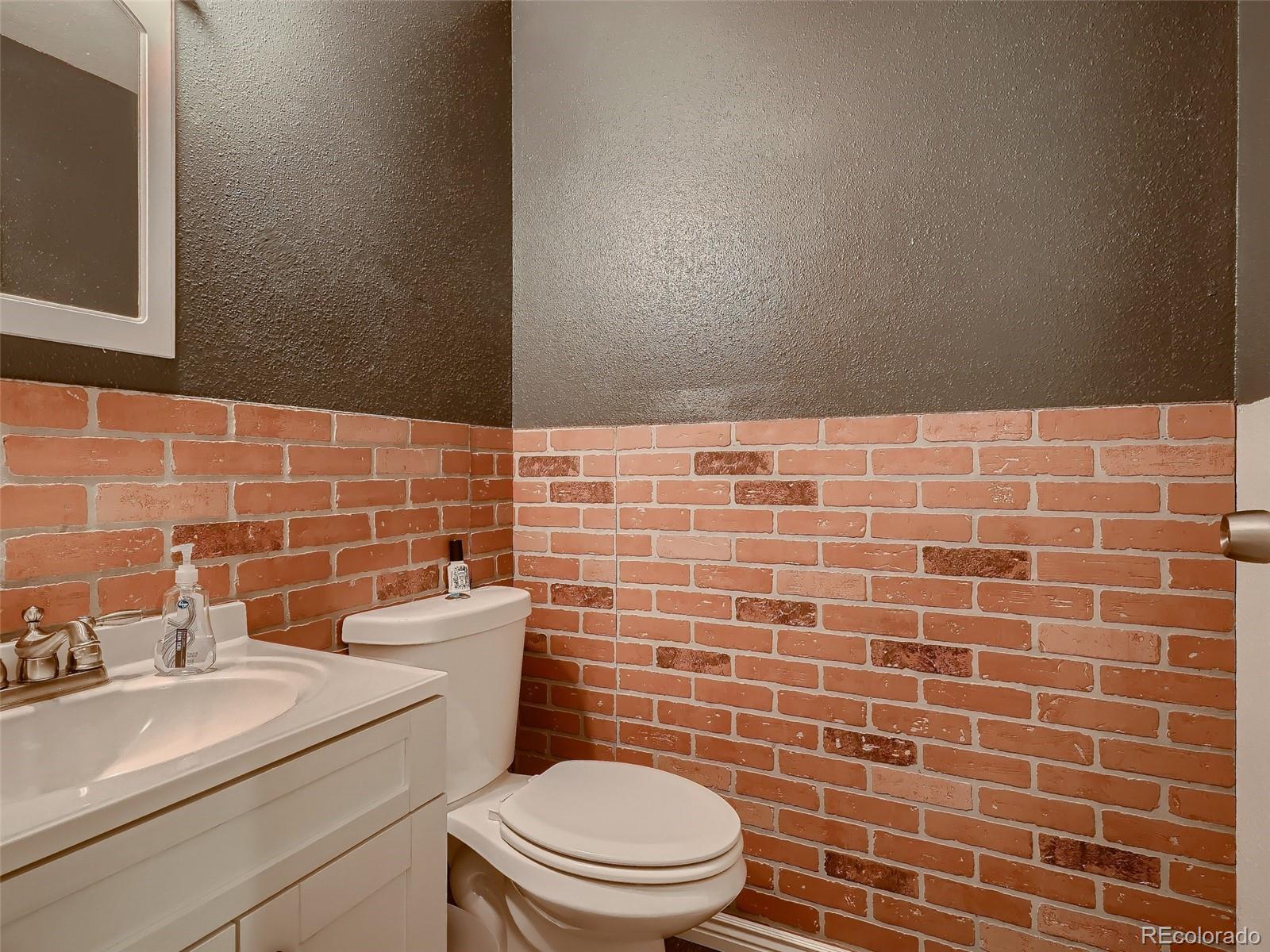 1230 South Reed Street, Unit 4 Lakewood, CO 80232 - Photo 12 of 28 a bathroom with a sink a toilet and a mirror