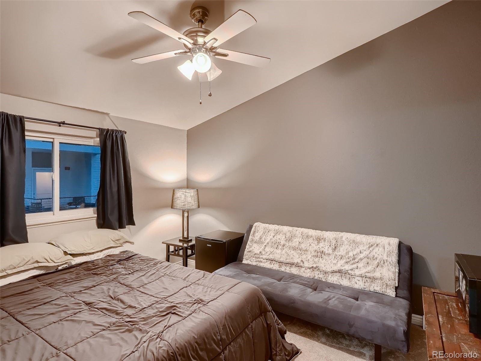 1230 South Reed Street, Unit 4 Lakewood, CO 80232 - Photo 13 of 28 a bedroom with a bed and a chandelier