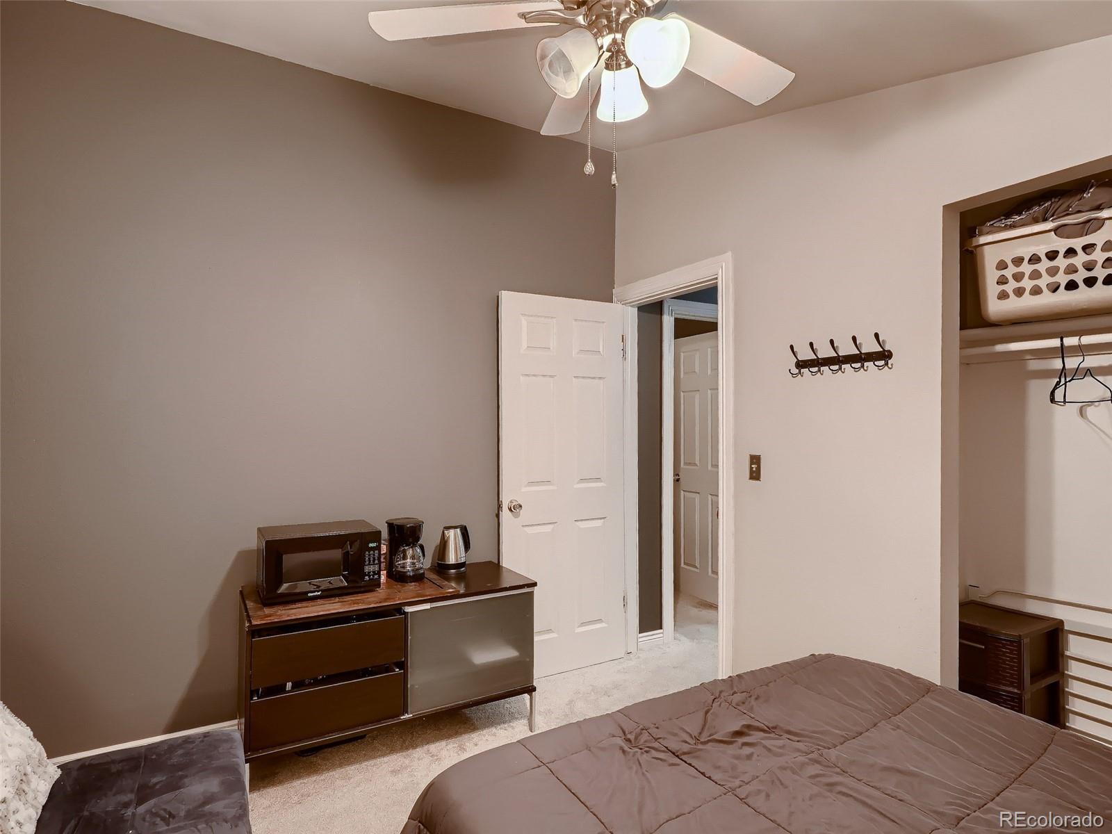 1230 South Reed Street, Unit 4 Lakewood, CO 80232 - Photo 14 of 28 a bedroom with a bed and a chandelier