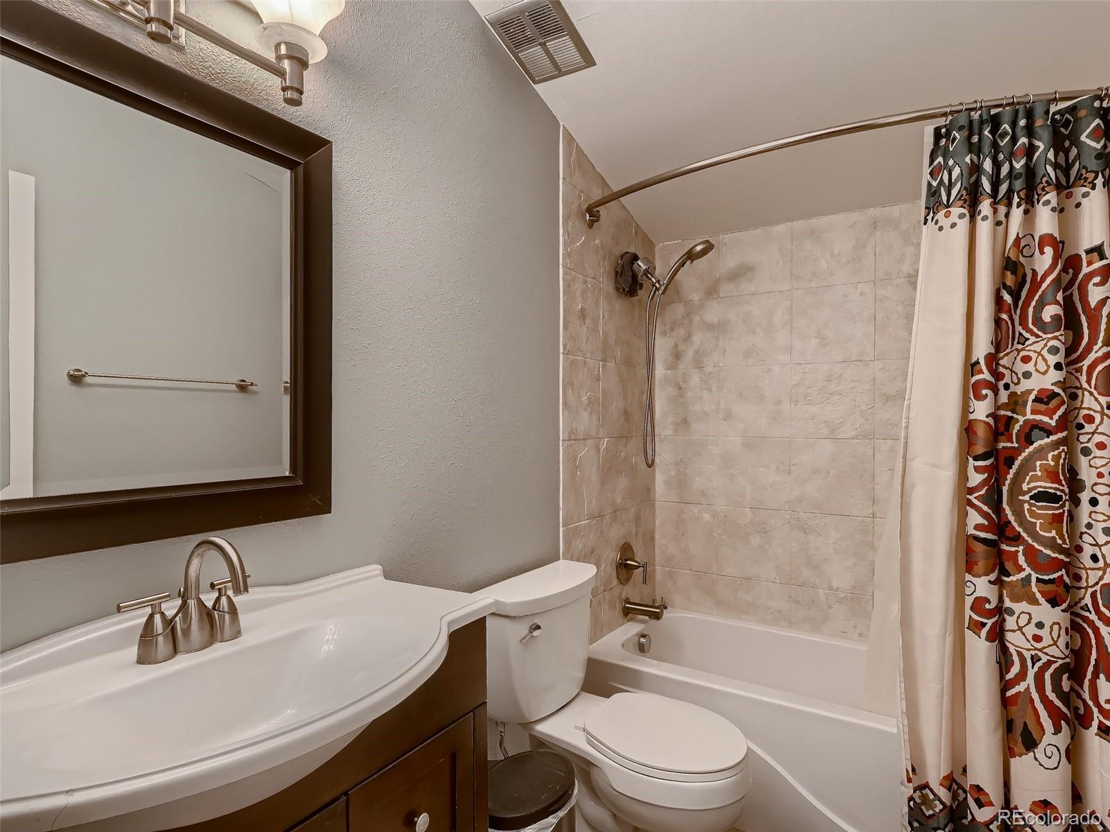 1230 South Reed Street, Unit 4 Lakewood, CO 80232 - Photo 15 of 28 a bathroom with a sink toilet and shower