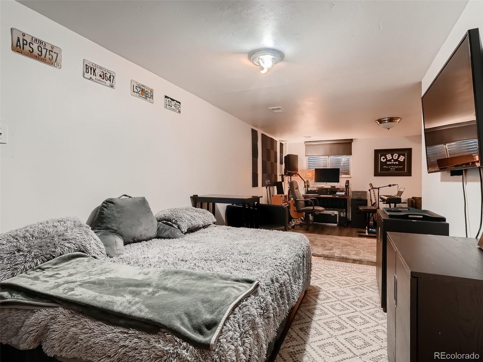 1230 South Reed Street, Unit 4 Lakewood, CO 80232 - Photo 21 of 28 a bedroom with bed a couch and flat screen tv