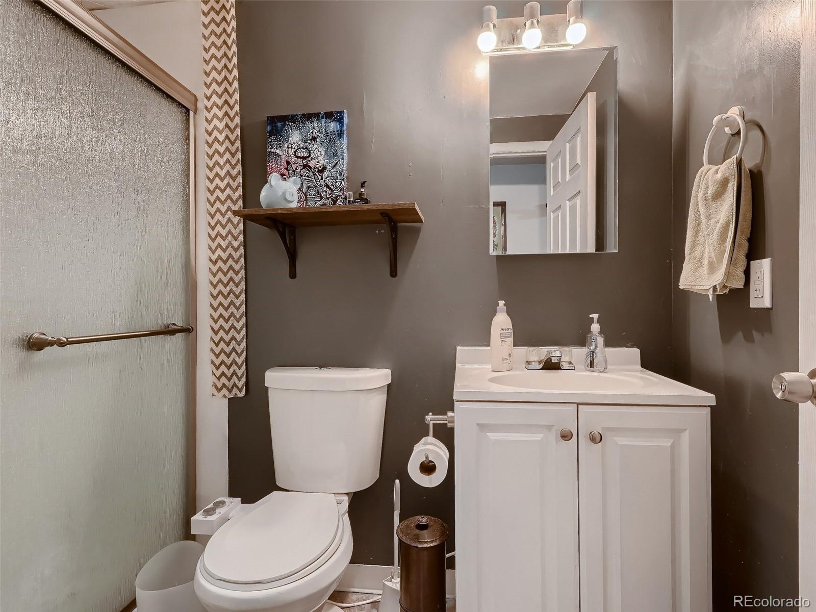 1230 South Reed Street, Unit 4 Lakewood, CO 80232 - Photo 23 of 28 a bathroom with a toilet sink and mirror