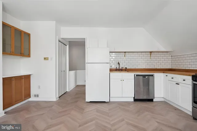 a view of kitchen with granite countertop cabinets and white appliances