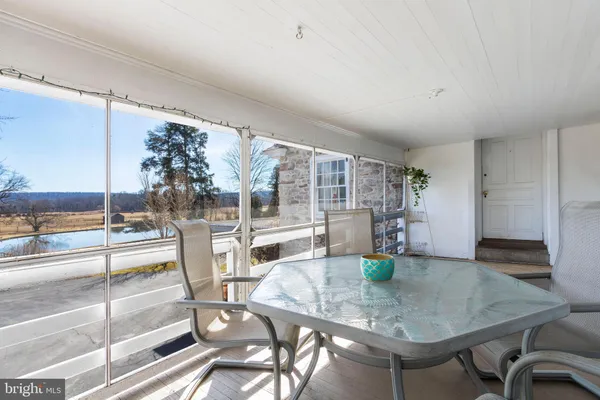 a dining room with furniture and a floor to ceiling window