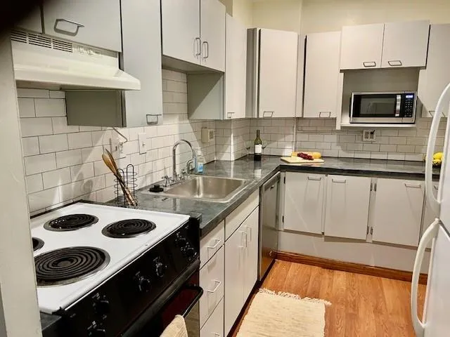 a kitchen with granite countertop a sink stainless steel appliances and cabinets