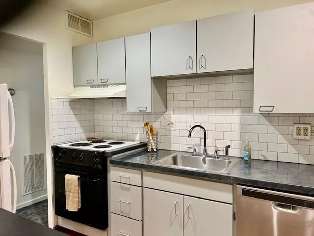 a kitchen with stainless steel appliances a sink a stove and a microwave
