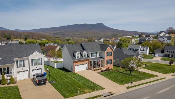an aerial view of a house with a garden and houses