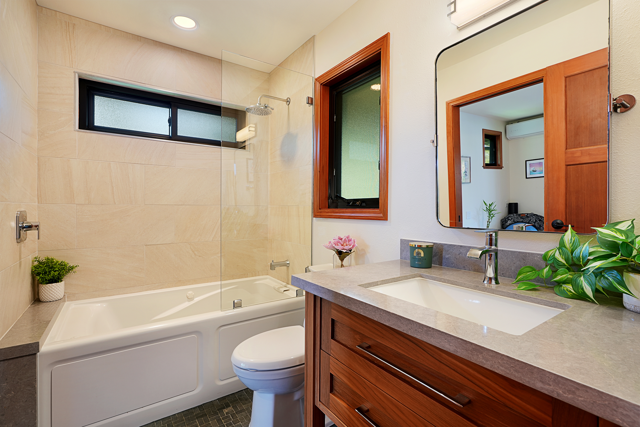 3667 Albert Road Princeville, HI 96722 - Photo 11 of 25 a bathroom with a granite countertop sink a toilet a mirror a vanity a bathtub and shower