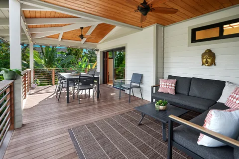 a view of a patio with dining table and chairs under a large umbrella
