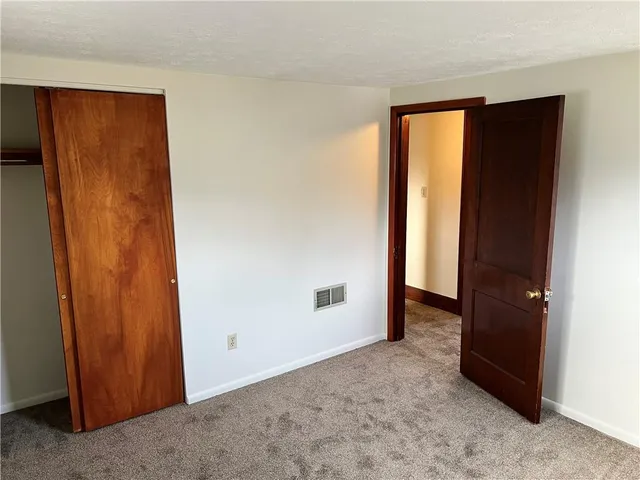 an empty room with closet and a window