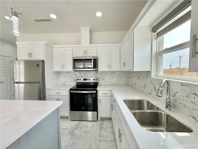 a kitchen with a sink stove and refrigerator