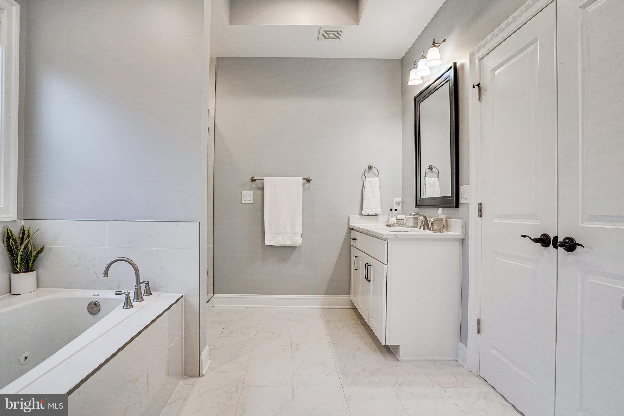 8733 Pohick Road Springfield, VA 22153 - Photo 22 of 40 a bathroom with a tub sink and mirror