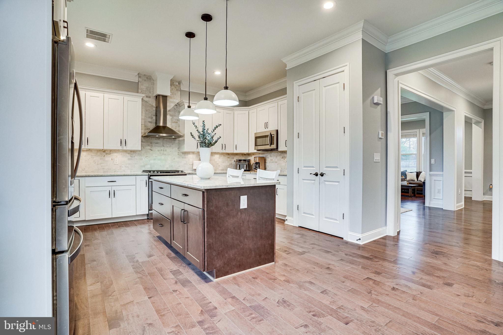 8733 Pohick Road Springfield, VA 22153 - Photo 9 of 40 a kitchen with stainless steel appliances granite countertop a sink a stove a refrigerator and white cabinets