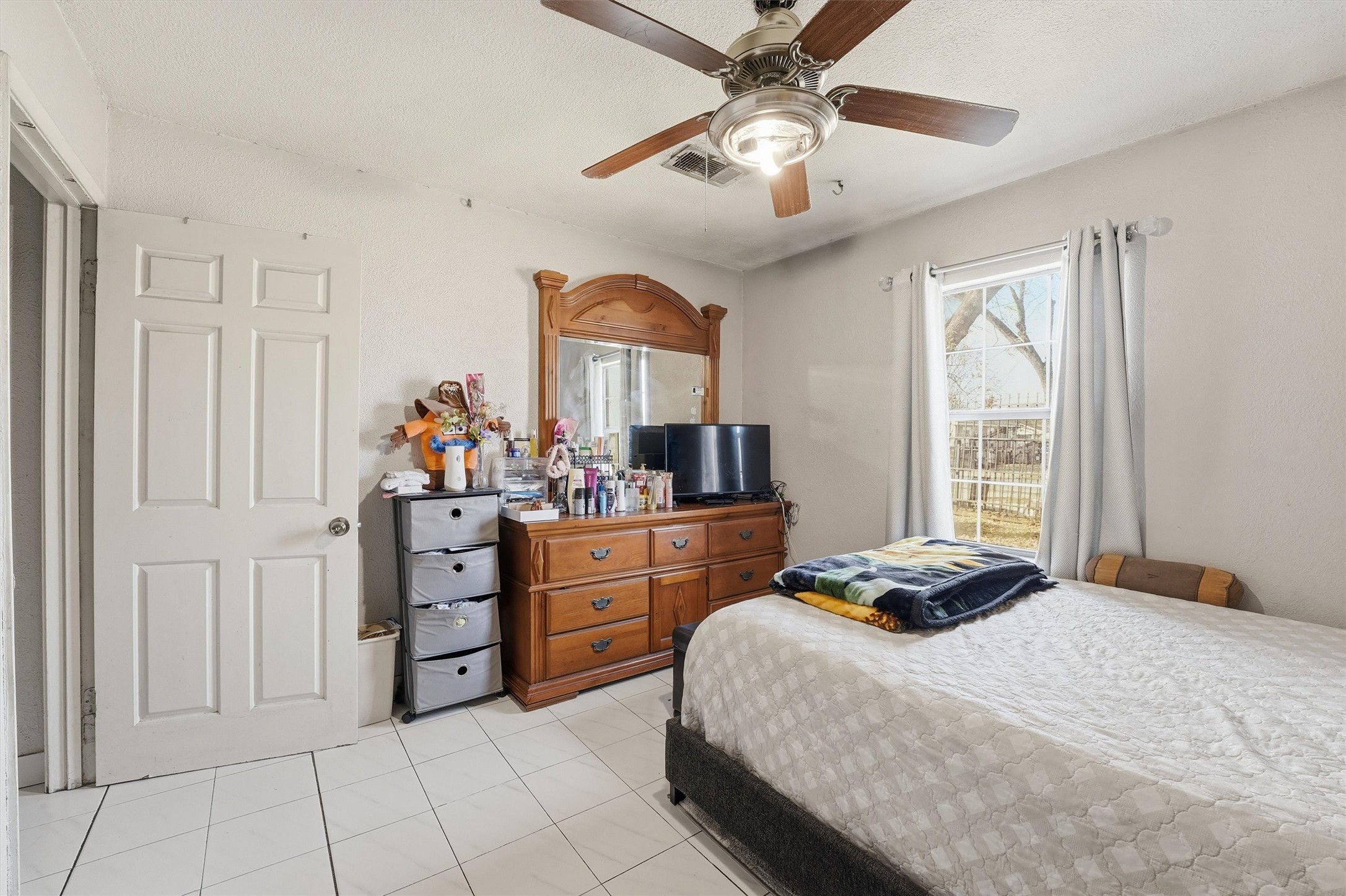 1002 Grenfell Lane Houston, TX 77076 - Photo 16 of 26 a bedroom with a bed and a chandelier