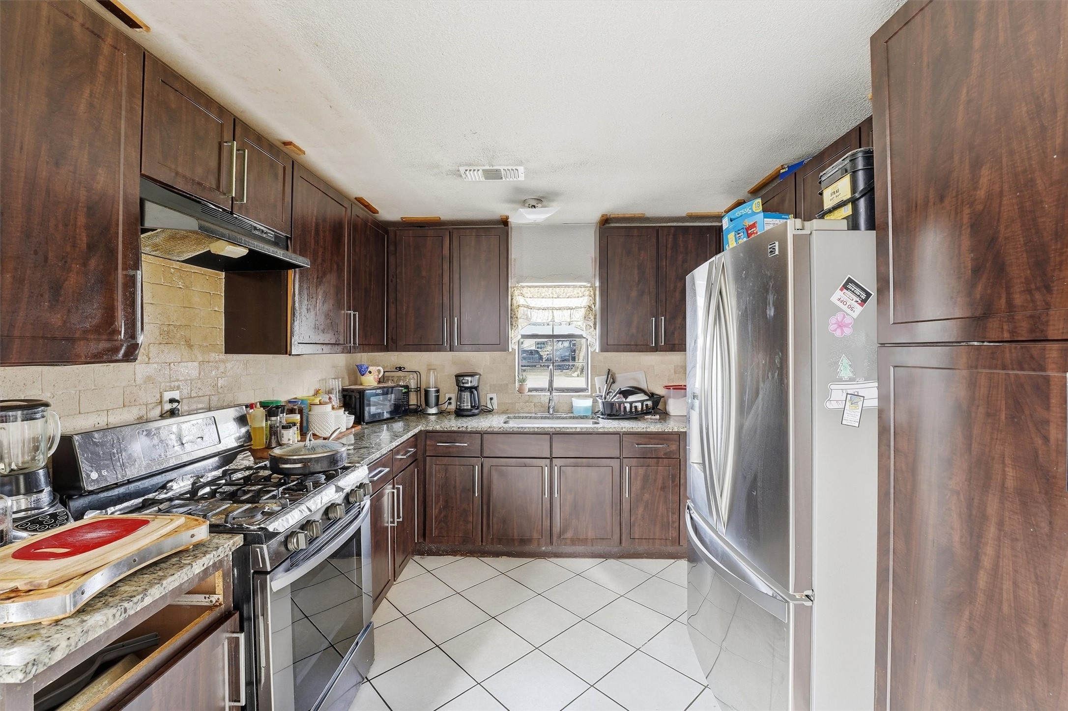 1002 Grenfell Lane Houston, TX 77076 - Photo 10 of 26 a kitchen with stainless steel appliances granite countertop a refrigerator stove and sink