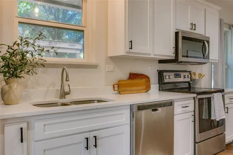 a kitchen with appliances a sink and cabinets