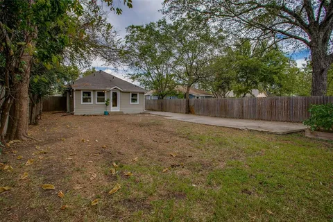 a front view of a house with a garden and trees