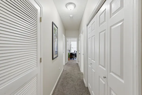 a view of a hallway with white walls and stairs