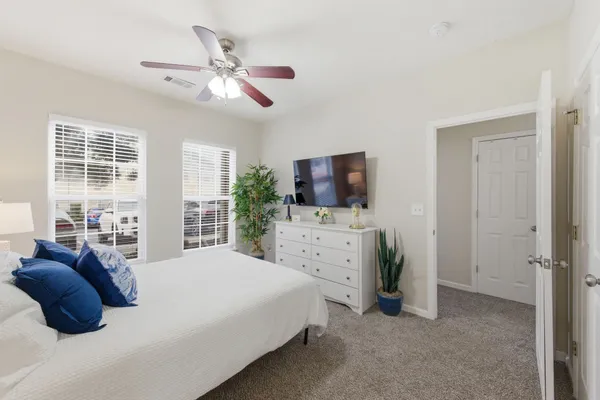 a bedroom with a bed a flat screen tv and a dresser