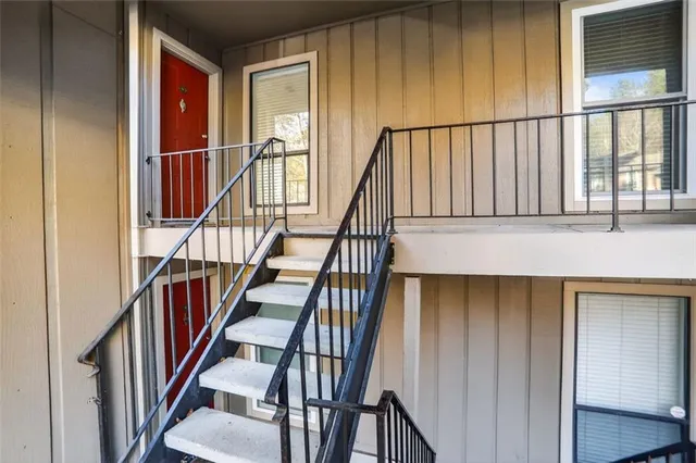 a view of staircase with lots of frames on wall and wooden floor