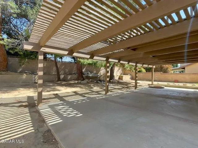 a view of a patio with table and chairs with wooden floor and fence