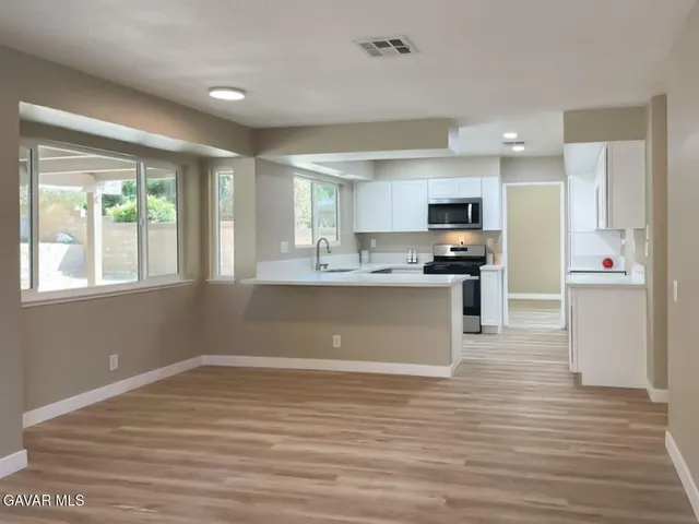 a kitchen with a sink stove microwave and cabinets