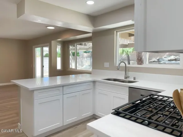 a kitchen with stainless steel appliances granite countertop a sink stove and cabinets