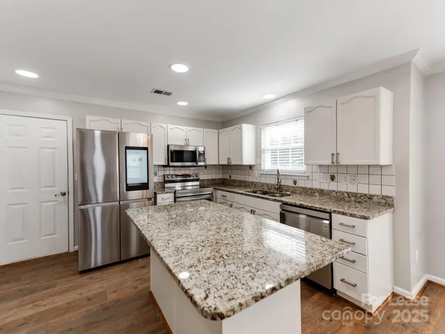 a kitchen with stainless steel appliances granite countertop a sink stove and refrigerator