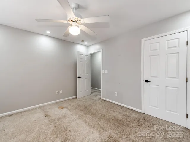 an empty room with fan and entrance