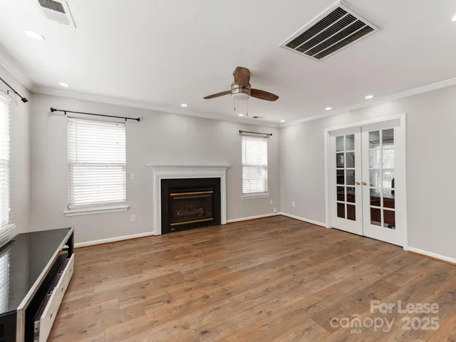 a view of an empty room with a window and fireplace