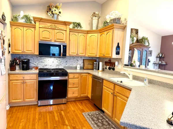 a kitchen with stainless steel appliances granite countertop a stove top oven a sink dishwasher and a microwave oven with a dishwasher