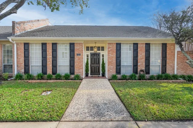 front view of a brick house with a yard