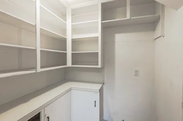 a kitchen with a white cabinets and a window