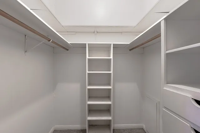 a view of walk in closet with empty racks