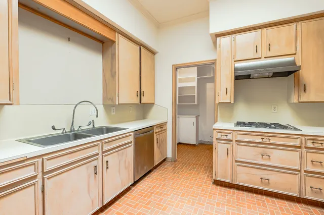 a view of cabinets a sink and a stove in a kitchen