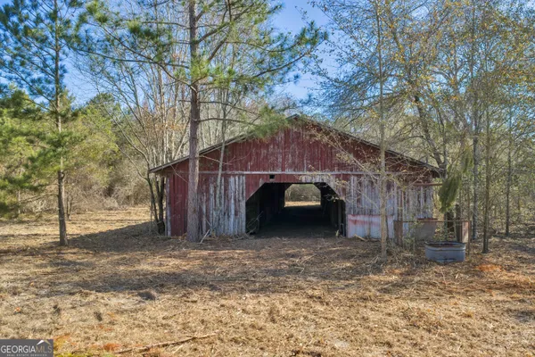 a view of a barn with big trees