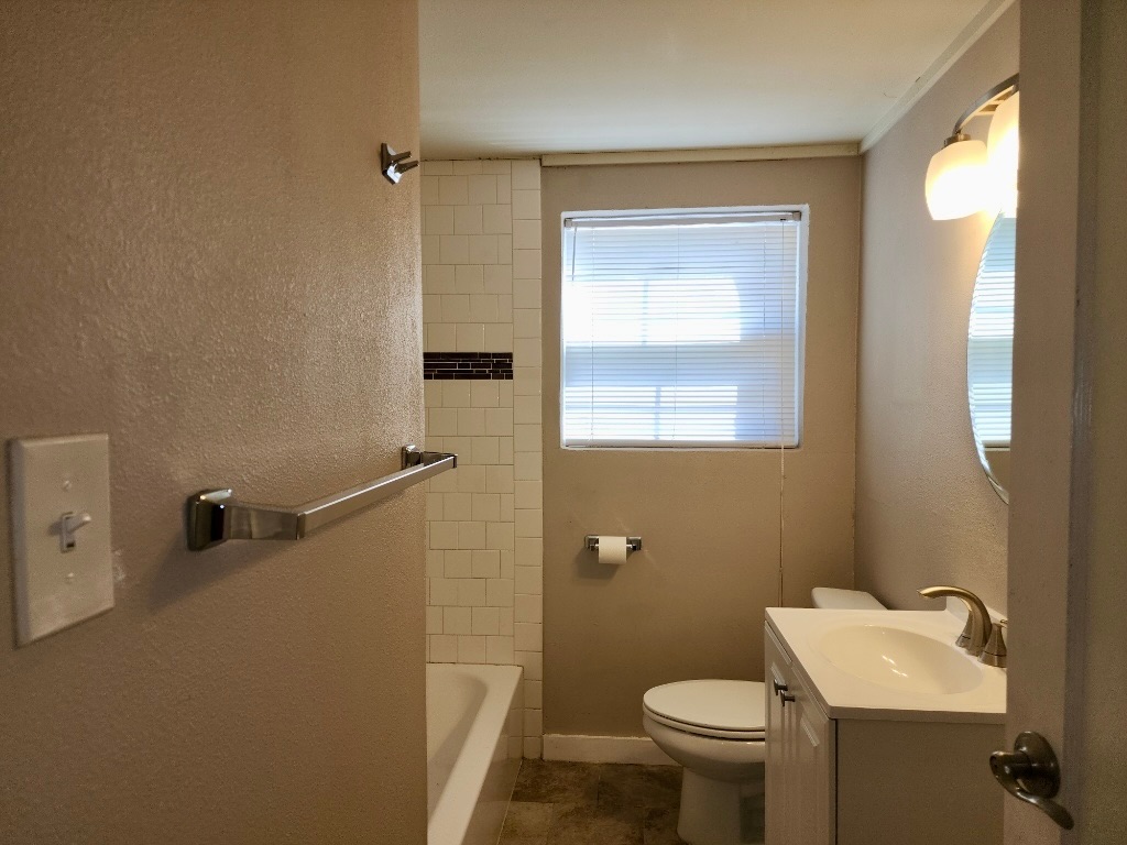1409 Kirkwood Road, Unit A Austin, TX 78722 - Photo 11 of 15 a bathroom with a toilet sink and a mirror