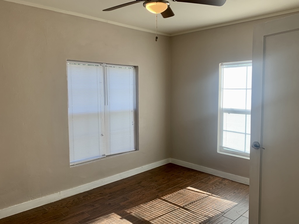 1409 Kirkwood Road, Unit A Austin, TX 78722 - Photo 12 of 15 a view of an empty room with wooden floor and a window