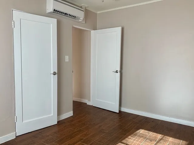 a view of an empty room with wooden floor