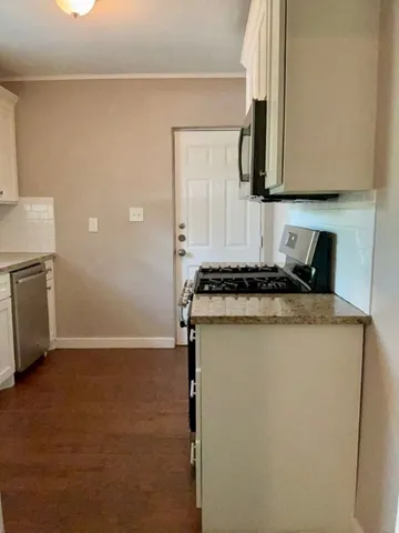a kitchen with granite countertop cabinets stainless steel appliances and a counter space