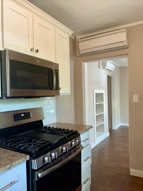 1409 Kirkwood Road, Unit A Austin, TX 78722 - Photo 5 of 15 a kitchen with stainless steel appliances a stove a microwave and cabinets