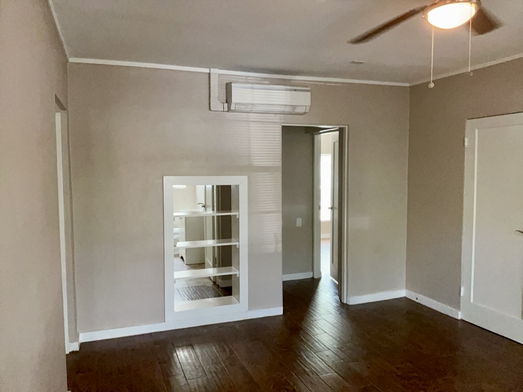 1409 Kirkwood Road, Unit A Austin, TX 78722 - Photo 7 of 15 an empty room with wooden floor fan and window