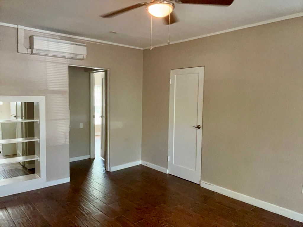 1409 Kirkwood Road, Unit A Austin, TX 78722 - Photo 8 of 15 an empty room with wooden floor fan and windows