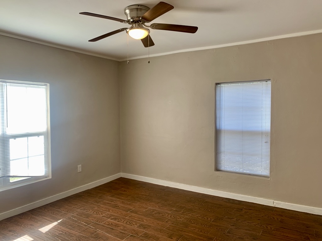 1409 Kirkwood Road, Unit A Austin, TX 78722 - Photo 9 of 15 a view of an empty room with wooden floor and a window
